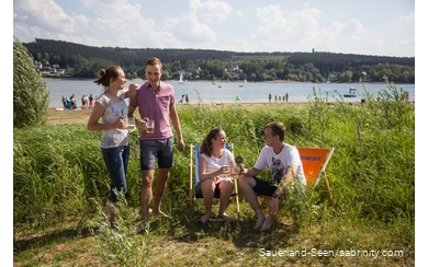 Freunde trinken zusammen ein Bier auf der Liegewiese