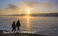 Wanderer am Möhnesee bei Sonnenaufgang